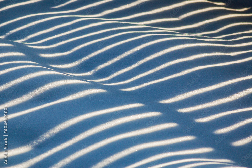 Light and shadow stripes on wavy snow cover
