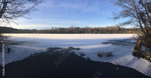 winter landscape, frozen snow covered lake with clear blue sky