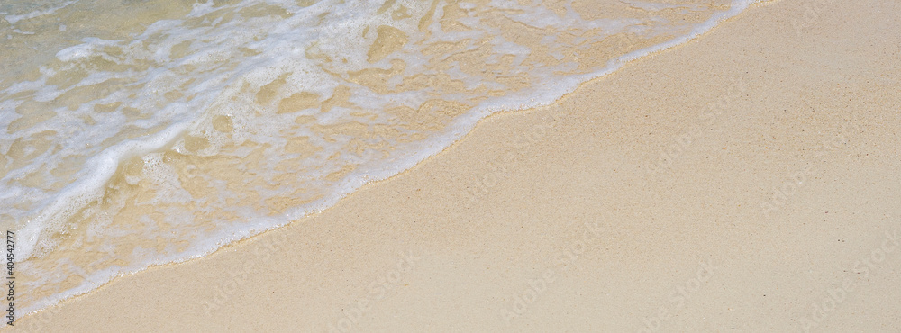 soft wave of the sea on sandy beach texture in bright summer day for banner background