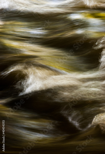 Close up abstract motion blue of waves in river with ripples colors and moving water
