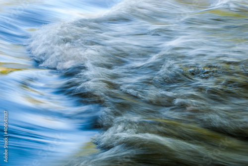 Close up abstract motion blue of waves in river with ripples colors and moving water