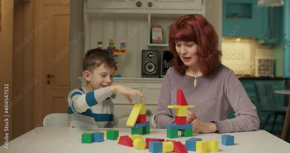 Autism psychologist working with child with autism with color wooden