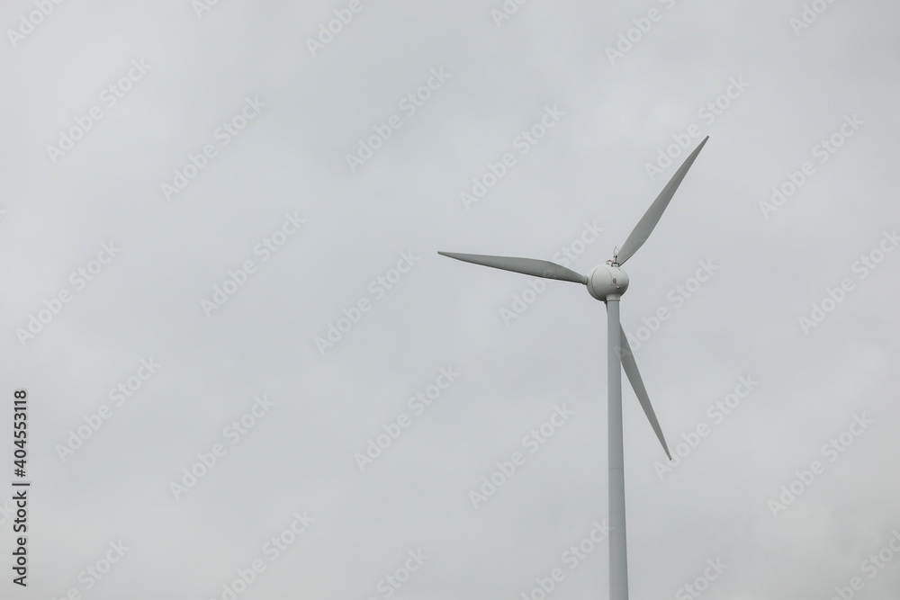 Wind turbines field in a stormy day with strong wind and rain. Wind farm eco field. Green ecological power energy generation.	