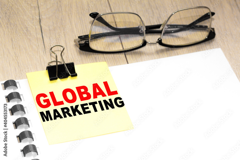 Text GLOBAL MARKETING on a notepad with eyeglasses and text documents. Could be for business, financial and marketing concepts Text GLOBAL MARKETING on a notepad with eyeglasses and text documents. Could be for business, financial and marketing concepts