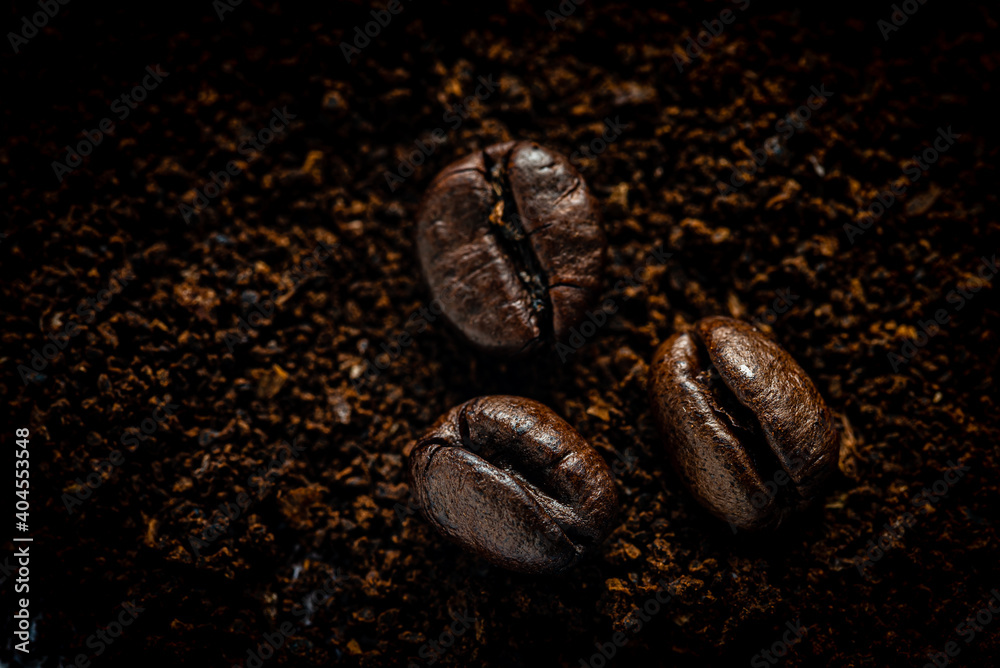 Makro Kaffeebohnen auf Kaffeepulver dunkel