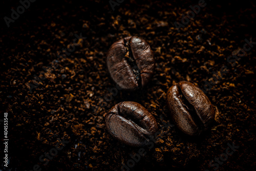 Makro Kaffeebohnen auf Kaffeepulver dunkel © dietwalther