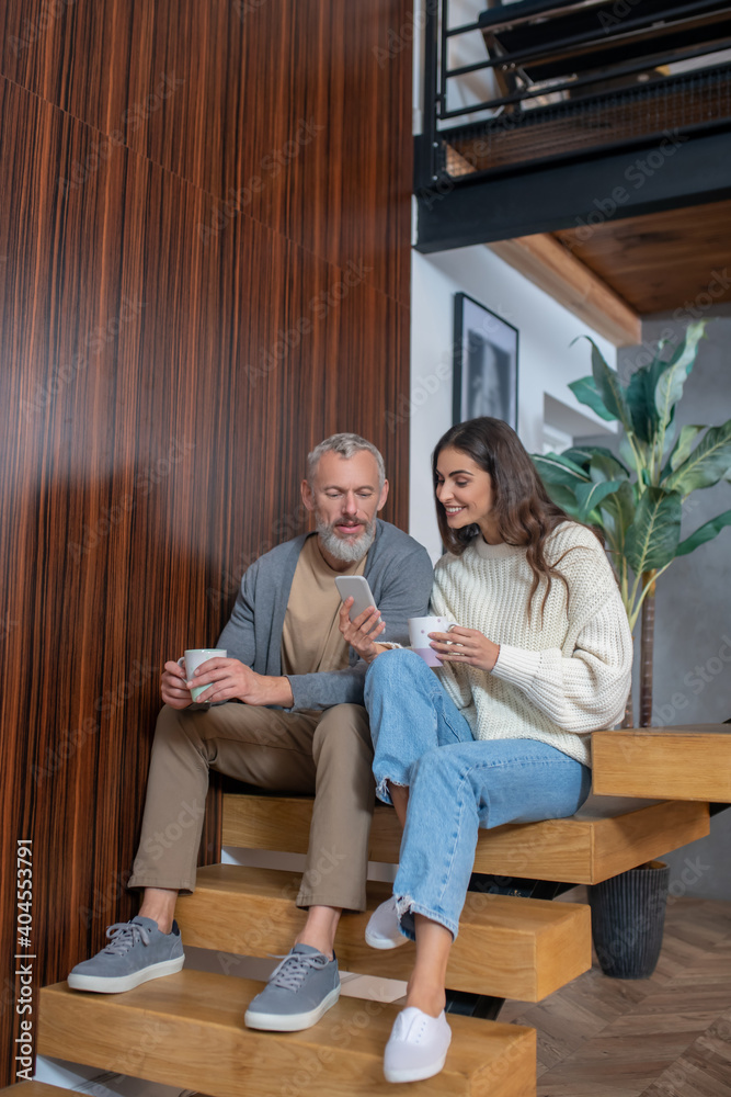 Obraz premium Married couple sitting on the stairs and talking