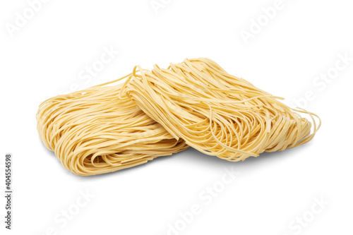 Dry strips of egg noodles (pasta nests) isolated on white background.