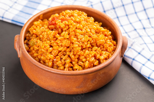 Traditional turkish bulgur pilaf with tomato sause in plate
