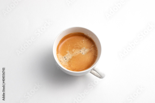 A white ceramic cup of freshly brewed coffee. Coffee cream on the drink