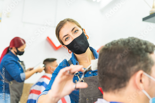 Barber Woman Cutting Man Hair at the Barbershop Wearing Mask.