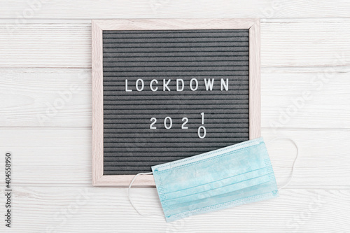 Flatlay letter board with message text lockdown 2021. White protective gloves, medical masck for face. photo