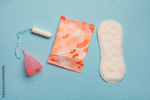 menstruation products, intimate hygiene and protection, sanitary pads, tampon and menstruation cup on blue background