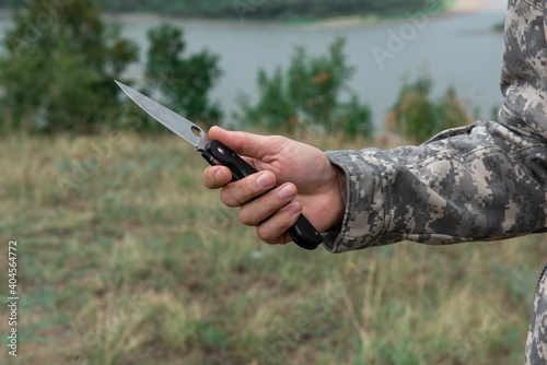 A man with a knife in the forest. Travel or military concept