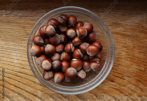 Hazelnut in glass bowl on wooden background. Organic hazelnut harvest. 