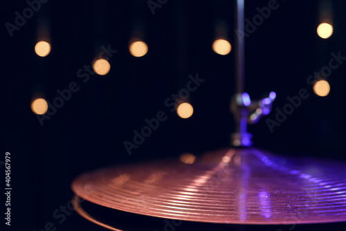 Drum hi-hat in the dark on a blurred background with lights.