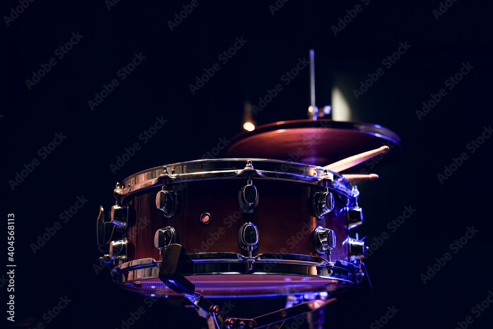 Naklejka premium Snare drum and drumsticks close up in dark.