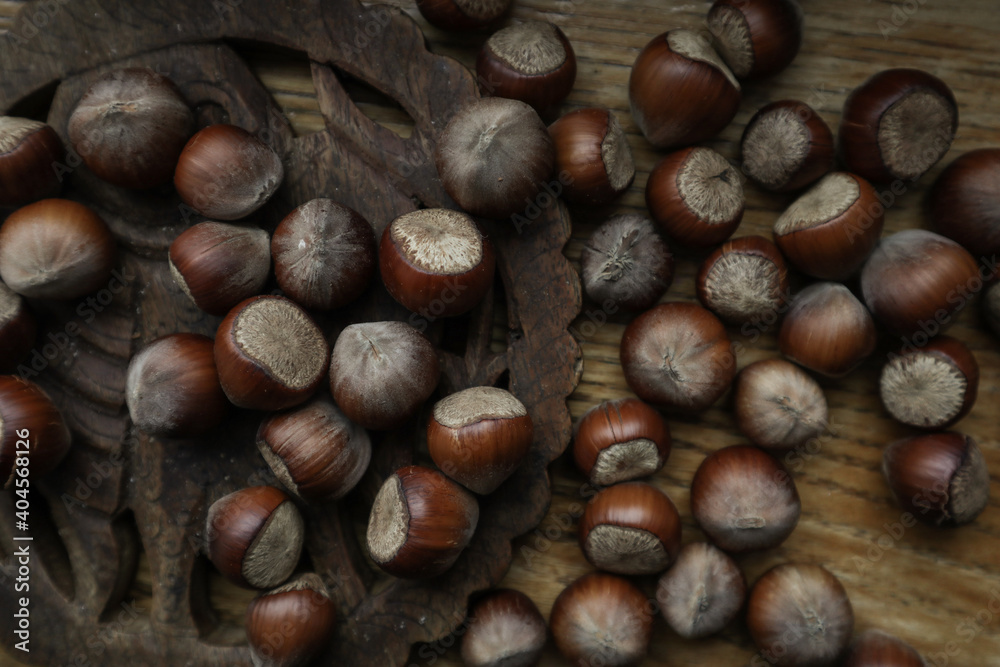 Top view Hazelnuts in nutshell, cracked nuts, wooden background.
Top view Hazelnuts in nutshell, cracked nuts, wooden background.