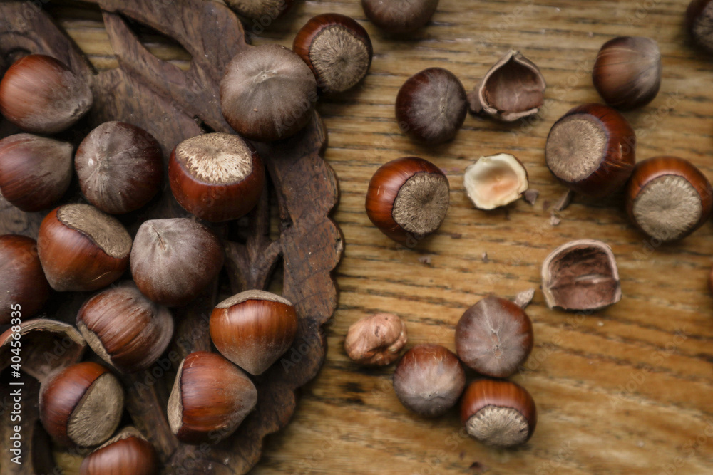 Top view Hazelnuts in nutshell, cracked nuts, wooden background.
Top view Hazelnuts in nutshell, cracked nuts, wooden background.
