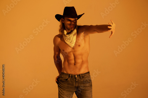 Sexy sport muscle strongface blond guy with long hair in cowbow hat on orange yellow isolated  font background photo