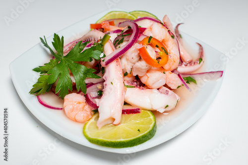 Typical Peruvian food, squid ceviche, shrimp and white fish with purple onion and a good tiger milk. Side view.