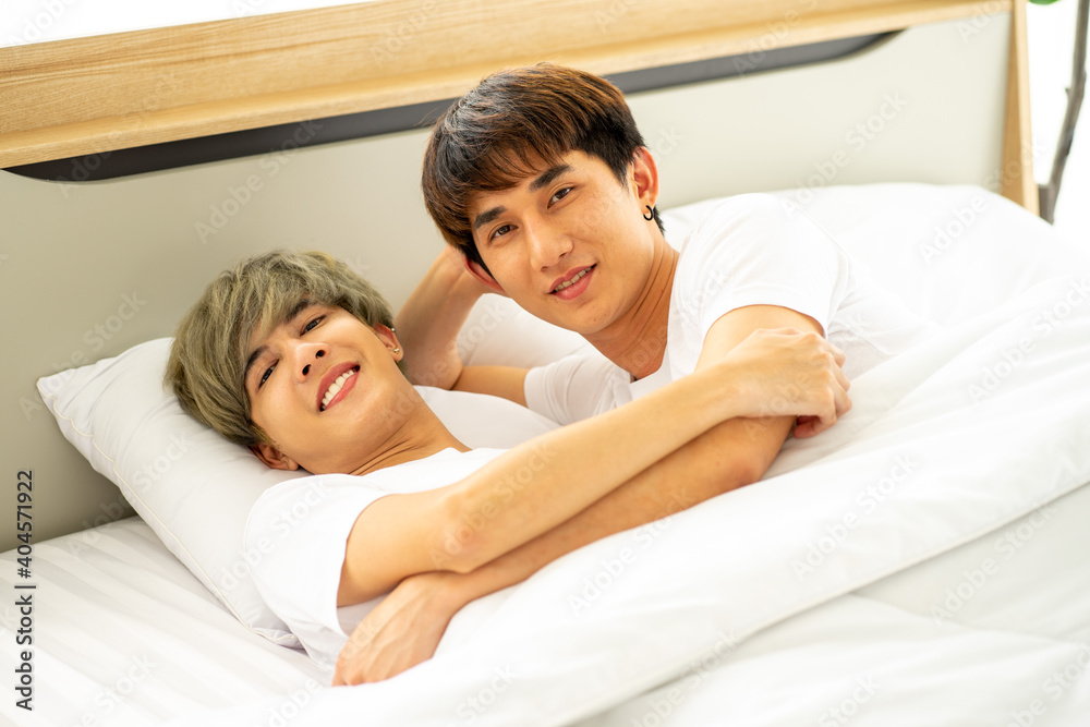 same sex couple lovers LGBTQ lying on bed together same sex couple lovers LGBTQ lying on bed together