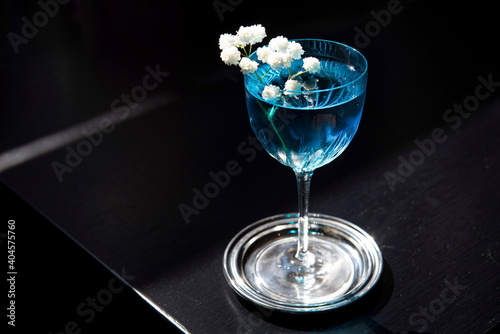 Blue curaçao cocktail garnished with white flowers photo
