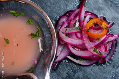 Peruvian Ceviche served in a signature cuisine. Close-up of purple onion and tiger's milk in a bowl. photo