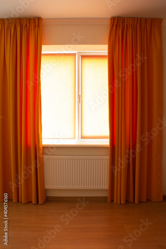 Beautiful orange curtains and roller blinds in an apartment