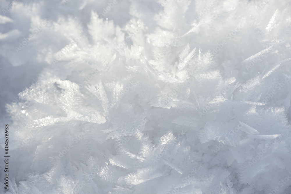 Obraz premium Hoarfrost background texture. Fresh ice and snow winter backdrop with snowflakes and mounds. Seasonal wallpaper. Frozen water geometrical shapes and figures. Cold weather atmospheric precipitation.