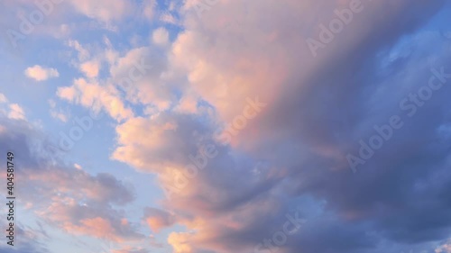 Timelapse of clouds only in the sky, at sunset, with tints of yellow, orange, pink, purple.