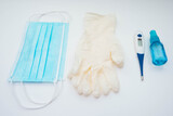 thermometer, gloves, face mask and antiseptic on a white background