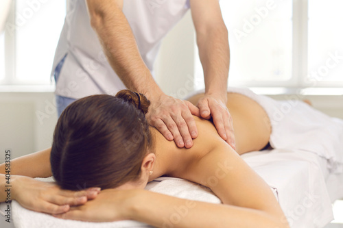 Woman patient getting back massage from professional masseur