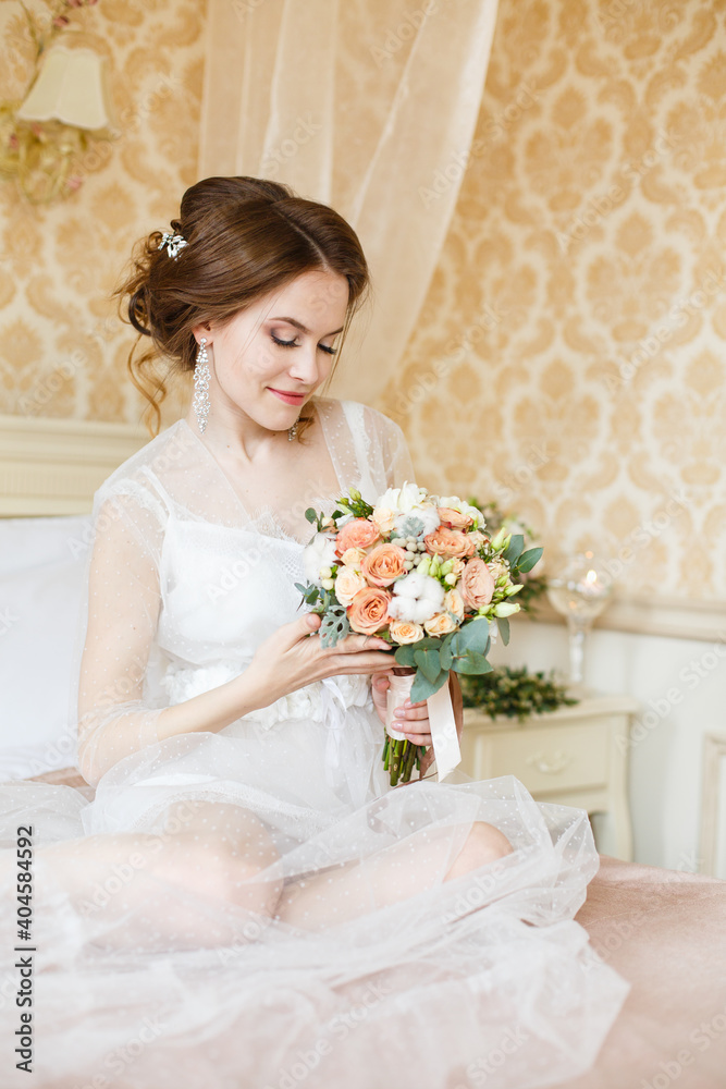 Pretty young Bride.Brown-haired woman with classic wedding hair-style. Boudoir morning of the bride. Pretty young Bride.Brown-haired woman with classic wedding hair-style. Boudoir morning of the bride.