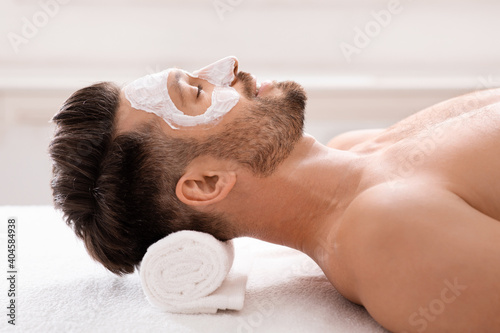 Relaxed bearded man with white face mask on photo