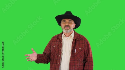 Ranch owner in a cowboy hat walking and telling a story on a Green Screen, Chroma Key. photo