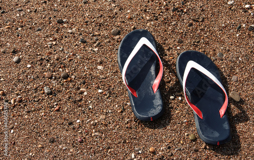 Men's sandals on the sea sand. Marine background.