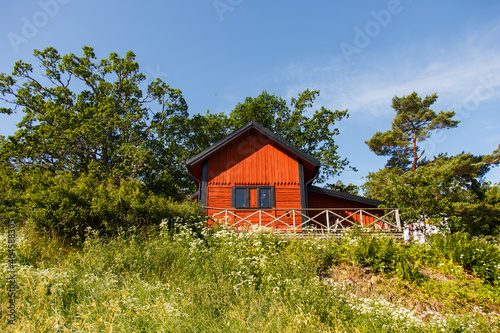 Red summer garden cottage in Sweeden. Traditional Sweden wooden old house. Life on the one of Sweeden islands