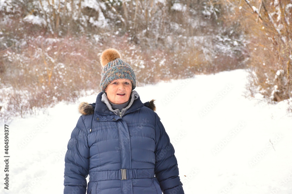 Retired woman with colorful jacket and hat in rural area with snow. Scene after the snowstorm called Filomena in Spain. January 2021. Retired woman with colorful jacket and hat in rural area with snow. Scene after the snowstorm called Filomena in Spain. January 2021.