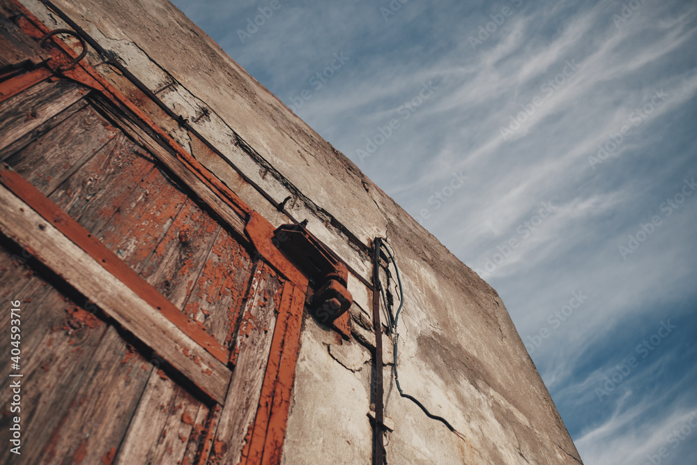 Old wooden hangar door. Sky with clouds on the background. Old wooden hangar door. Sky with clouds on the background.