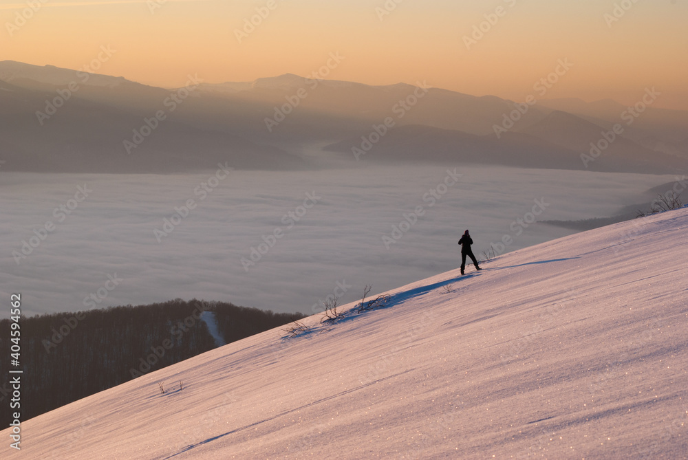 hiker on a mountain slope in winter hiker on a mountain slope in winter