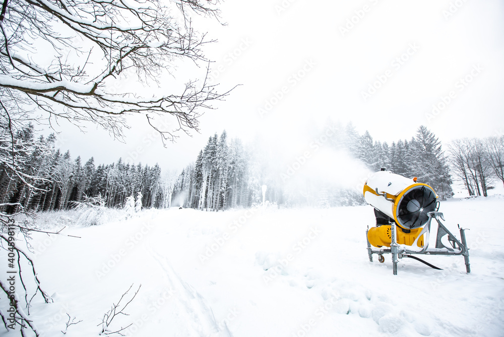 Snow cannon, machine or gun snowing the slopes or mountain for skiers ans snowboarders, artificial snow