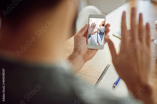 Close-up of African American doctor greeting his patient during video call over mobile phone. photo