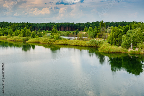 View on a lake in the abandoned sand quarry and dramatic sky