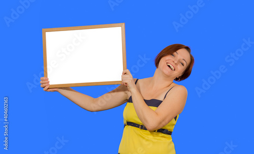 woman laughing with whiteboard in hands, blank mockup on blue background