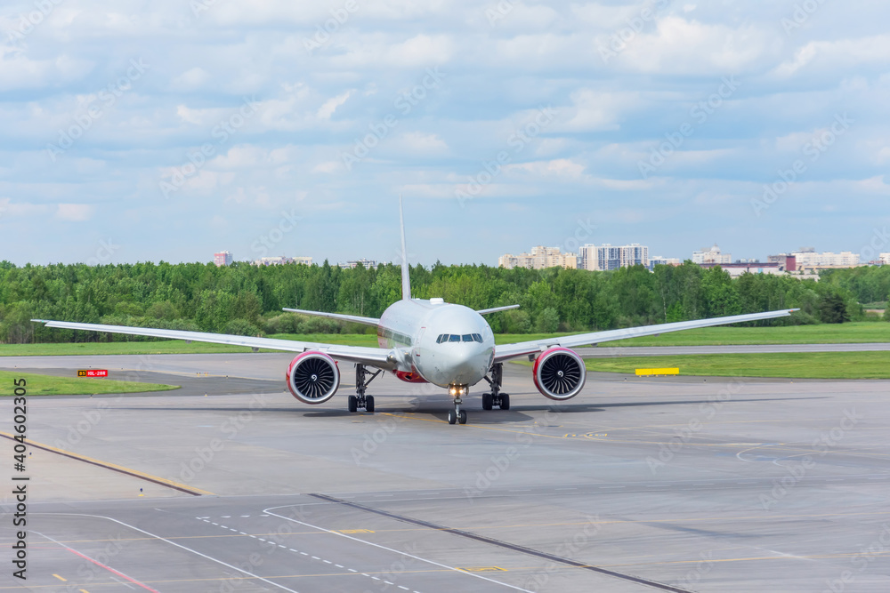 Front view of a large airplane on steering tracks and parking at the airport after landing. Front view of a large airplane on steering tracks and parking at the airport after landing.