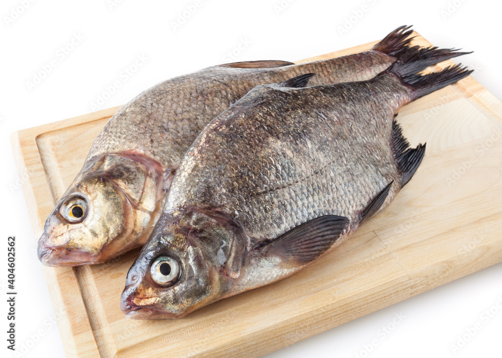 Common river breams on cutting board isolated on white background. Freshwater fish Common river breams on cutting board isolated on white background. Freshwater fish