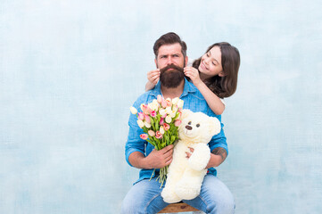 happy family portrait with teddy bear. spring flower bouquet. womens day. prepare tulips for mothers day. daughter and father celebrate birthday. girl greeting dad with fathers day. family love
