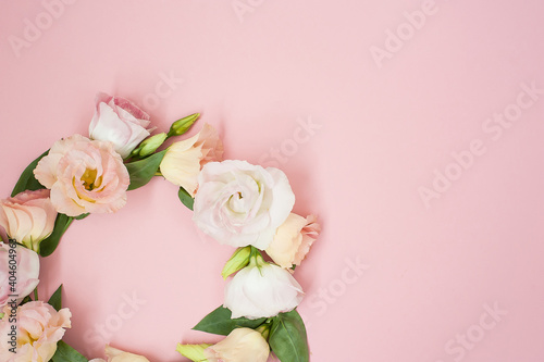 Creative layout made with pink flowers wreath on pastel pink background. Flat lay. Top view, frame with copy space.