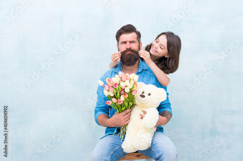 happy family portrait with teddy bear. spring flower bouquet. womens day. prepare tulips for mothers day. daughter and father celebrate birthday. girl greeting dad with fathers day. family love photo